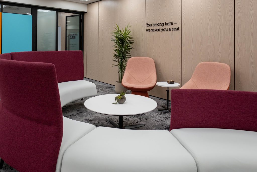 A cozy lounge area showcases Maple White Quartz tables and side tables provided by CNG Stone. 